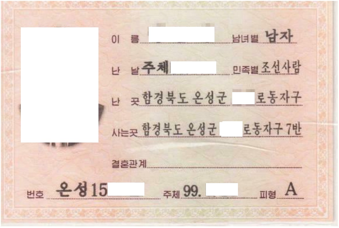 A North Korean identity document with some fields redacted.